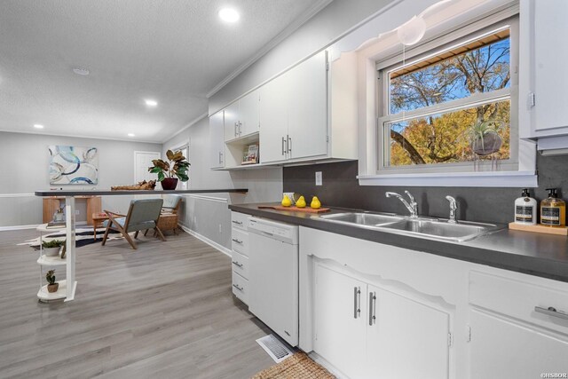 kitchen featuring dark countertops, white cabinets, and dishwasher