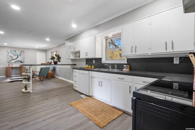 kitchen with black electric range, dark countertops, white cabinetry, a sink, and dishwasher