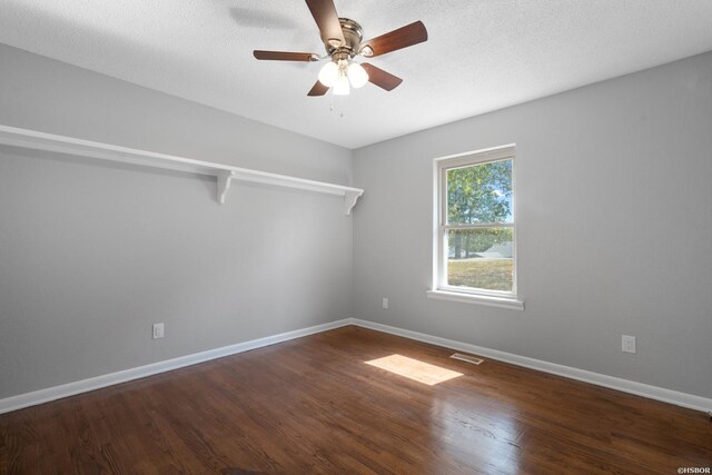 empty room featuring baseboards, visible vents, ceiling fan, wood finished floors, and a textured ceiling