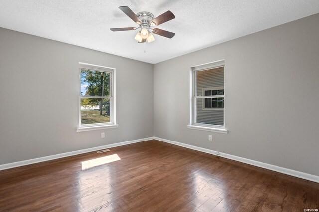 unfurnished room with a ceiling fan, dark wood finished floors, a textured ceiling, and baseboards