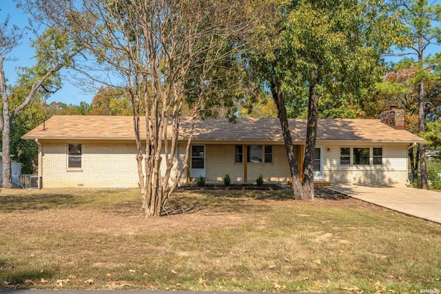 ranch-style house with a chimney, a front lawn, and brick siding