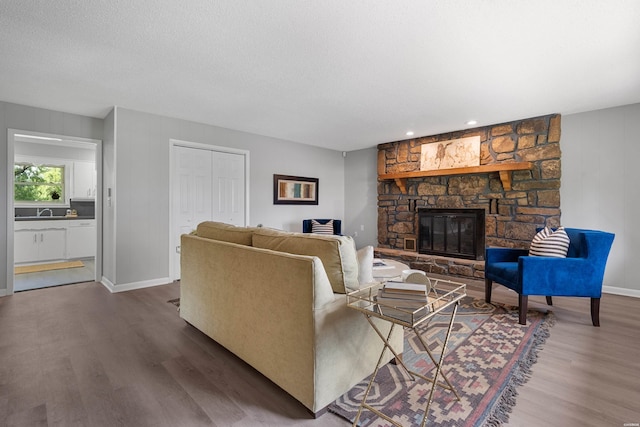 235 Echo Pt, Hot Springs, AR 71913 - living area with wood finished floors, a fireplace, and a textured ceiling