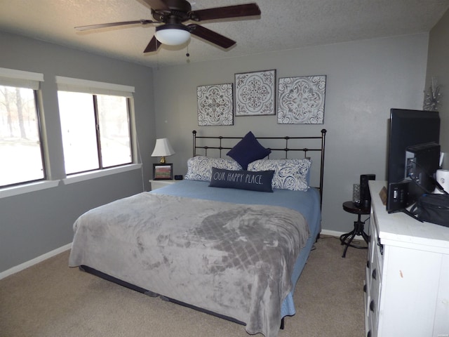 bedroom featuring light carpet, ceiling fan, baseboards, and a textured ceiling