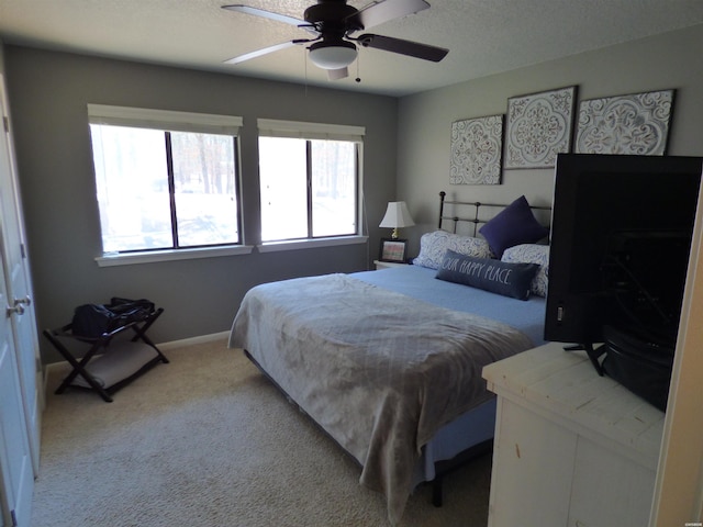 bedroom with a textured ceiling, baseboards, a ceiling fan, and light colored carpet