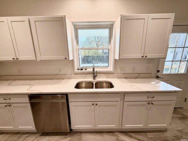 kitchen featuring a sink, white cabinetry, a healthy amount of sunlight, stainless steel dishwasher, and light stone countertops