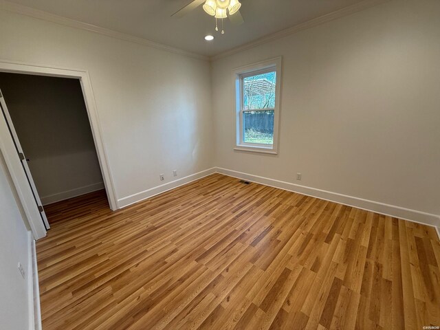 unfurnished bedroom featuring baseboards, ceiling fan, ornamental molding, and light wood-style floors