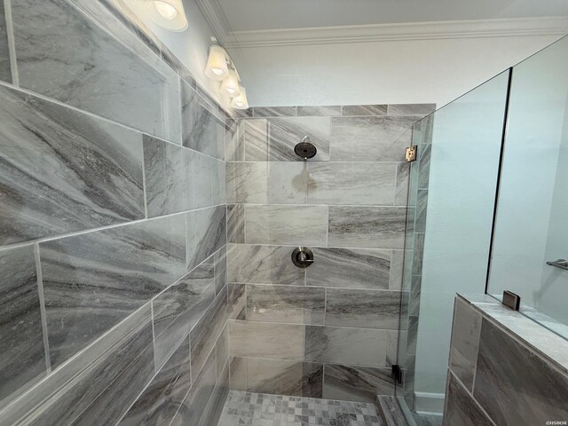 bathroom with ornamental molding and a tile shower