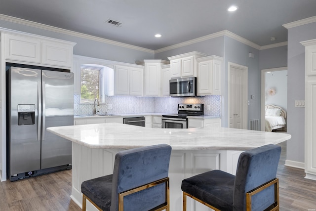 kitchen featuring white cabinets, stainless steel appliances, a sink, and wood finished floors