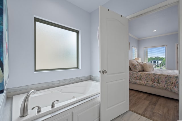 ensuite bathroom featuring ornamental molding, ensuite bathroom, and a jetted tub