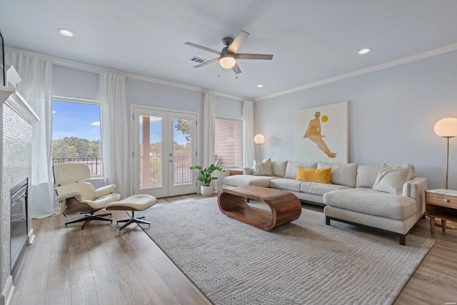 living room featuring ceiling fan, french doors, wood finished floors, visible vents, and ornamental molding
