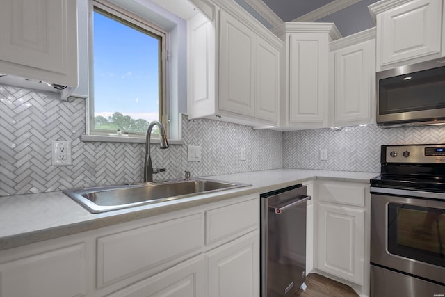 kitchen featuring decorative backsplash, light countertops, white cabinets, a sink, and appliances with stainless steel finishes