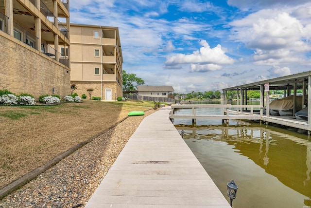 view of dock featuring a water view and a yard