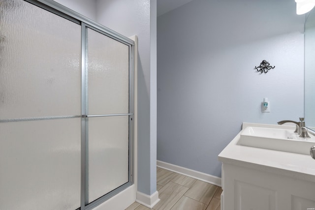 full bathroom with baseboards, a shower stall, wood finished floors, and vanity