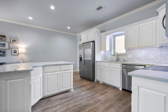 kitchen featuring visible vents, ornamental molding, light wood-type flooring, a sink, and appliances with stainless steel finishes