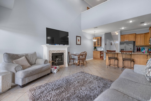 181 Fish Hatchery Rd Unit P2, Hot Springs, AR 71913 - living room featuring light tile patterned floors, ornamental molding, a tiled fireplace, a high ceiling, and recessed lighting