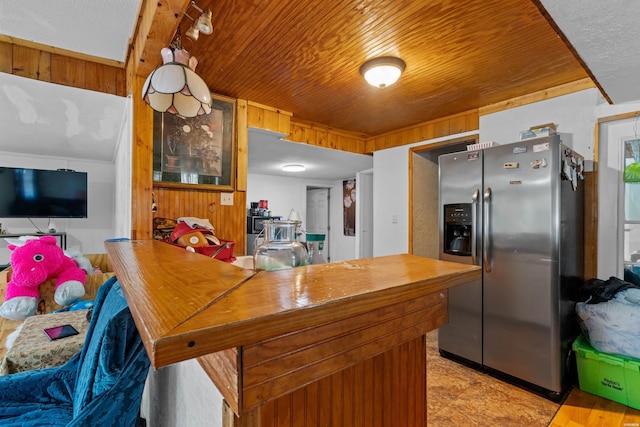 598 Timberlake Dr, Royal, AR 71968 - kitchen with a peninsula, wood walls, wooden ceiling, and stainless steel fridge