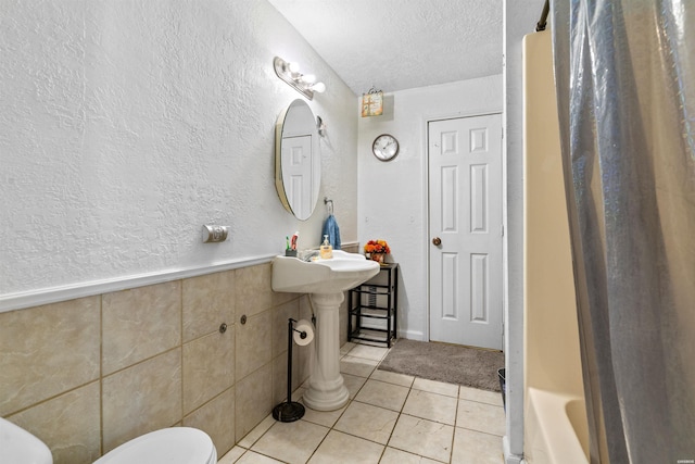 598 Timberlake Dr, Royal, AR 71968 - full bathroom featuring a textured ceiling, a textured wall, toilet, wainscoting, and tile patterned floors