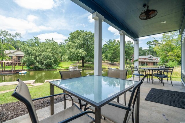 view of patio featuring a water view, outdoor dining area, and a ceiling fan