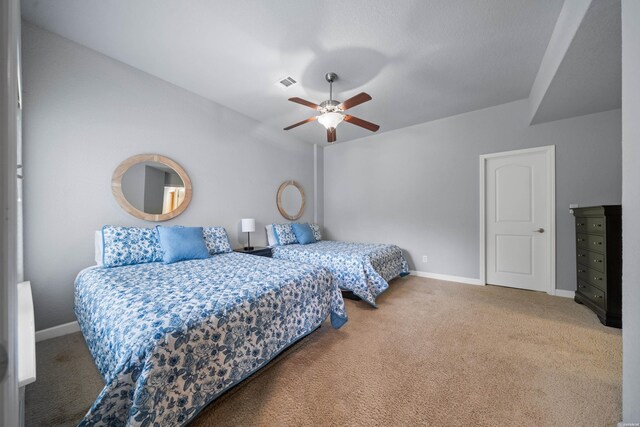 carpeted bedroom featuring ceiling fan, visible vents, and baseboards