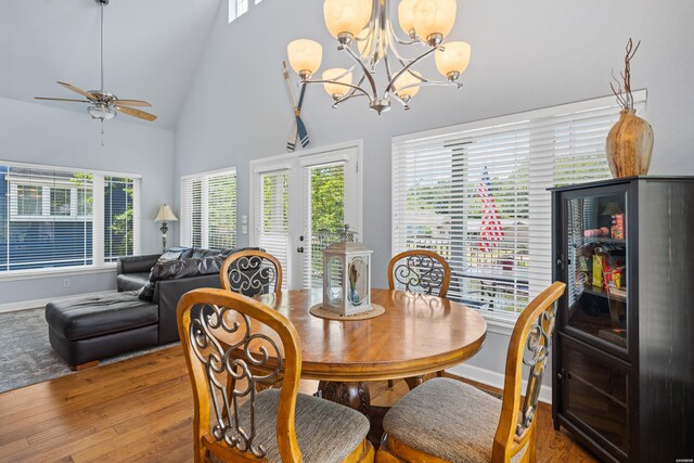 dining room featuring plenty of natural light, high vaulted ceiling, wood finished floors, and french doors