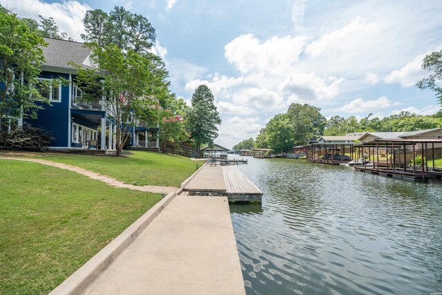 view of dock with a water view and a lawn