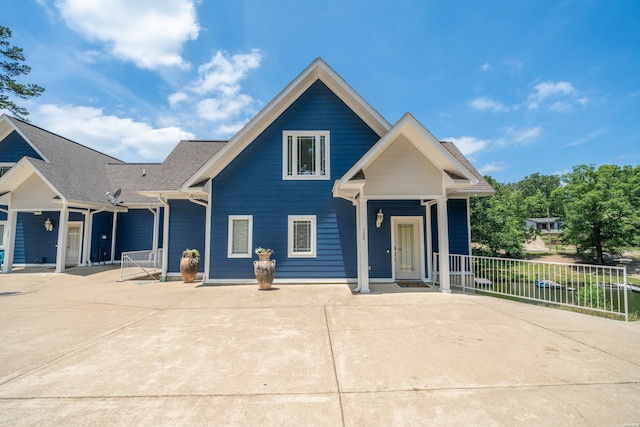 view of front of property featuring a shingled roof and fence