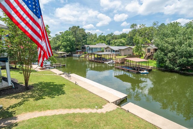 dock area with a water view and a lawn