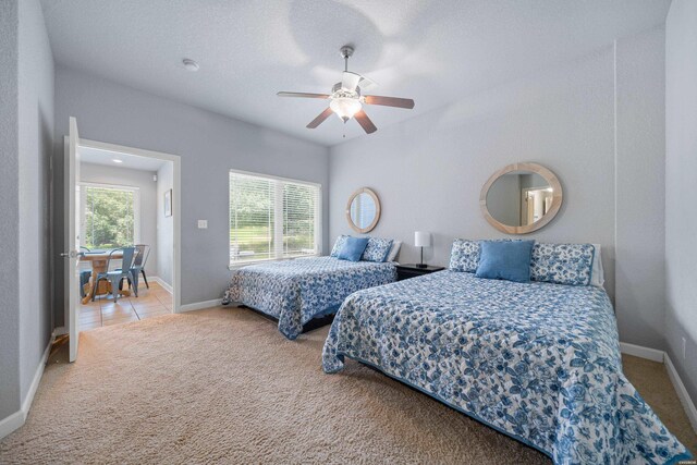 carpeted bedroom with multiple windows, baseboards, and a ceiling fan