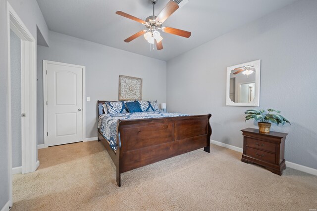 bedroom with light colored carpet, ceiling fan, and baseboards