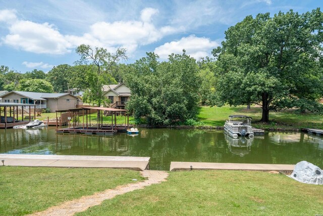 dock area with a lawn and a water view