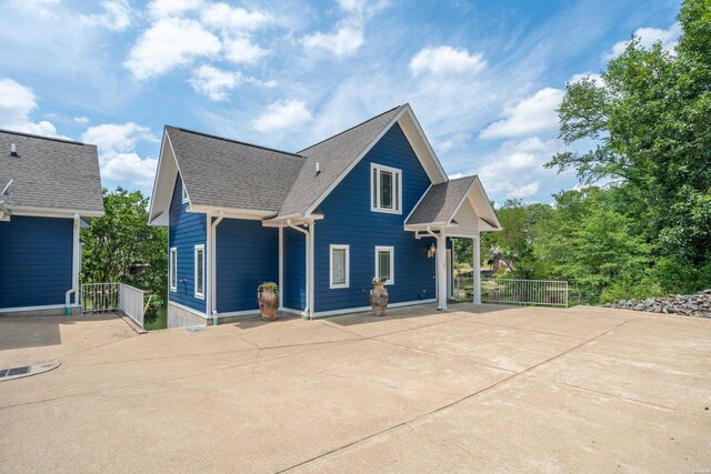 view of front of home featuring fence and roof with shingles