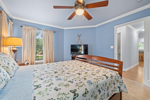 bedroom featuring ceiling fan, multiple windows, and ornamental molding