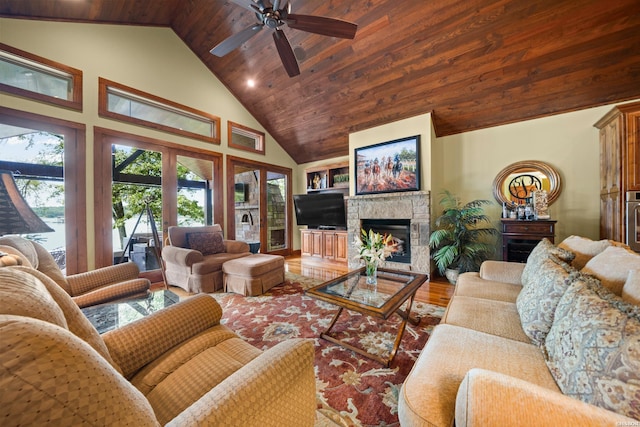 living area with high vaulted ceiling, wooden ceiling, a fireplace, wood finished floors, and a ceiling fan