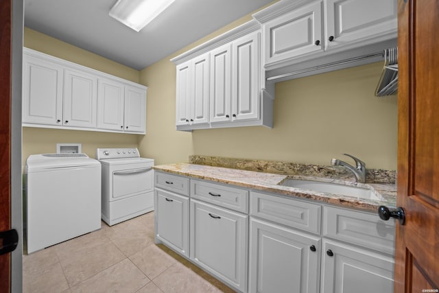 washroom with independent washer and dryer, cabinet space, a sink, and light tile patterned floors