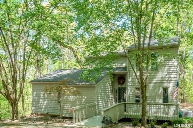 view of front of home with a wooden deck and cooling unit