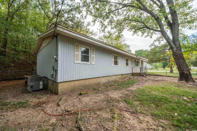 view of side of home featuring fence and central air condition unit