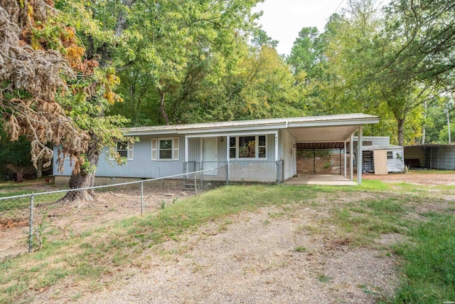 view of front of house featuring a carport, metal roof, driveway, and fence