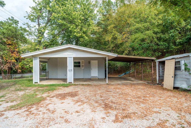 view of front of property with an outdoor structure and fence