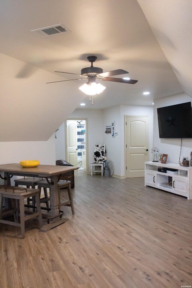 dining space featuring ceiling fan, vaulted ceiling, and wood finished floors