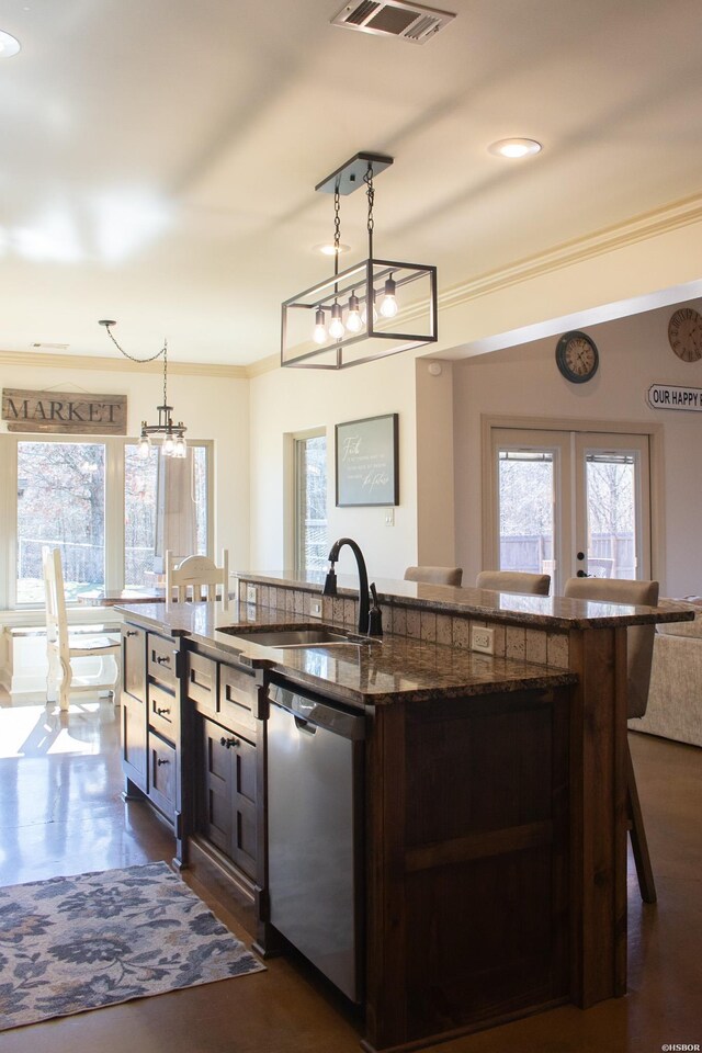 kitchen with a sink, visible vents, a kitchen breakfast bar, dishwasher, and decorative light fixtures