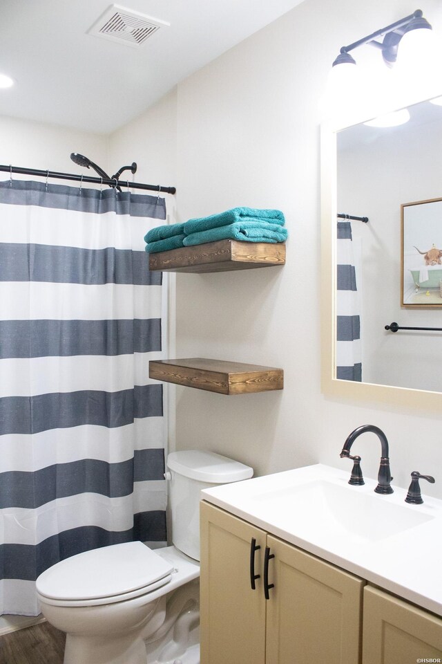 bathroom with toilet, vanity, visible vents, and a shower with curtain