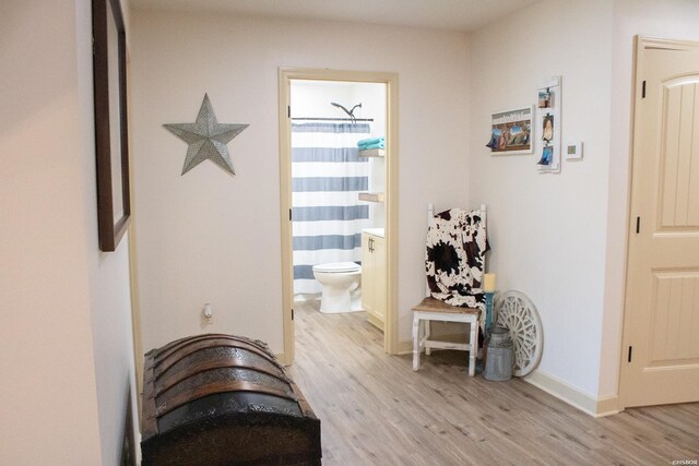 hallway with light wood-type flooring and baseboards