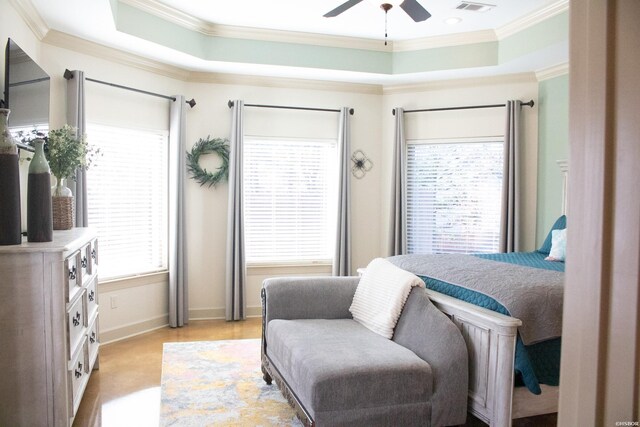 bedroom with ceiling fan, a tray ceiling, baseboards, and crown molding