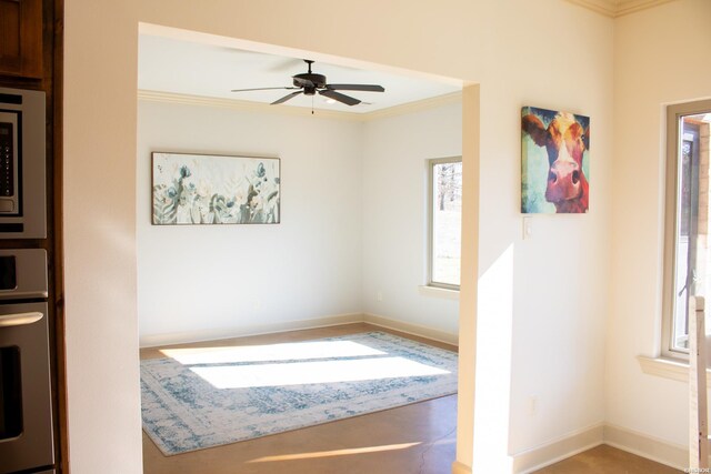 empty room featuring ornamental molding, ceiling fan, and baseboards