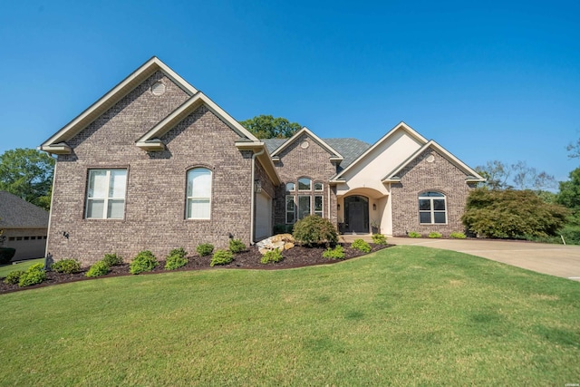 view of front facade with concrete driveway, a front lawn, and brick siding