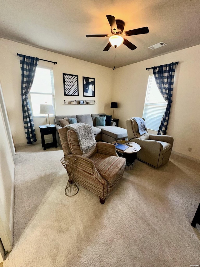 carpeted living area featuring visible vents and ceiling fan