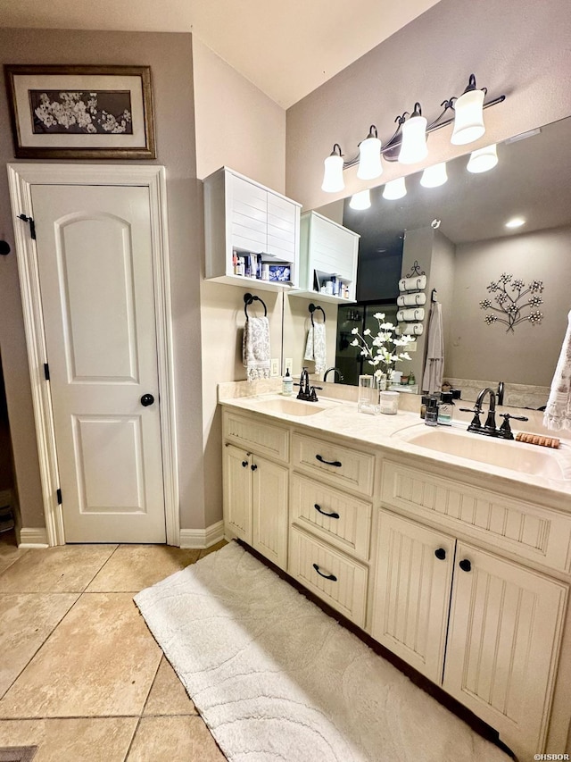 bathroom featuring double vanity, tile patterned flooring, baseboards, and a sink