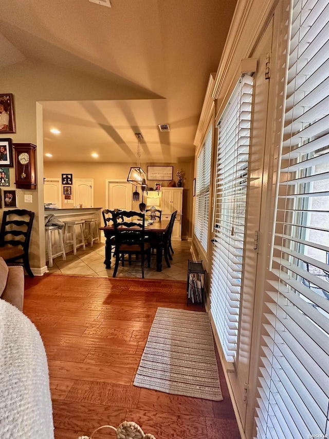 dining area with a wealth of natural light, vaulted ceiling, and light wood-style flooring