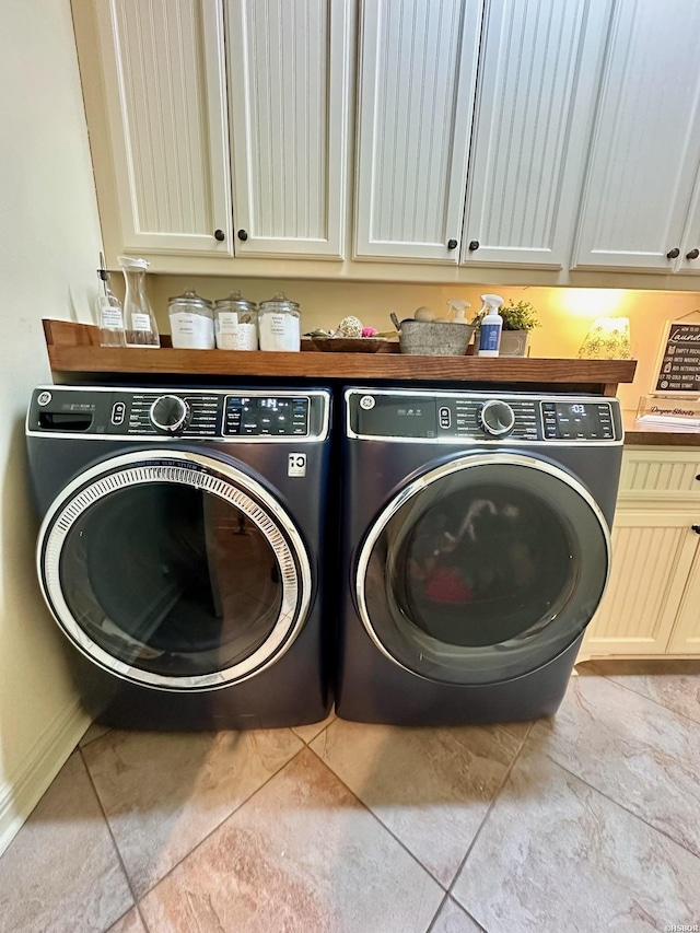 washroom featuring cabinet space and washing machine and clothes dryer