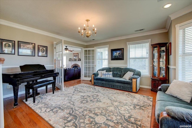 living room with french doors, plenty of natural light, wood finished floors, and crown molding